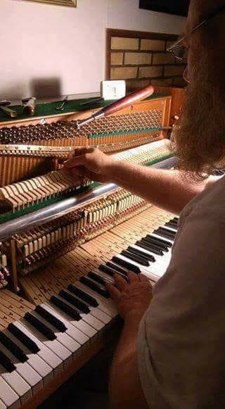 Geir Barlaup stemmer et åpent piano med stemmenøkkel